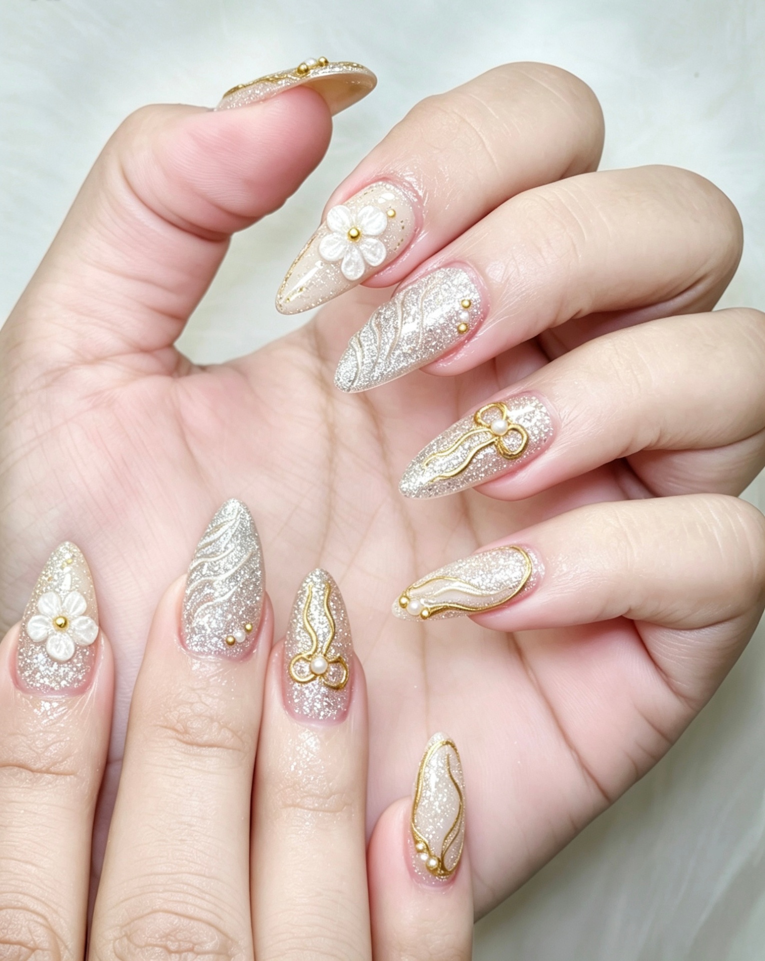 Elegant nail art close-up in warm ivory and gold tones